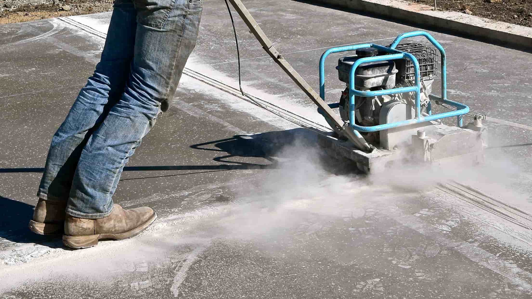 Person cutting expansion joints; how to repair concrete expansion joints